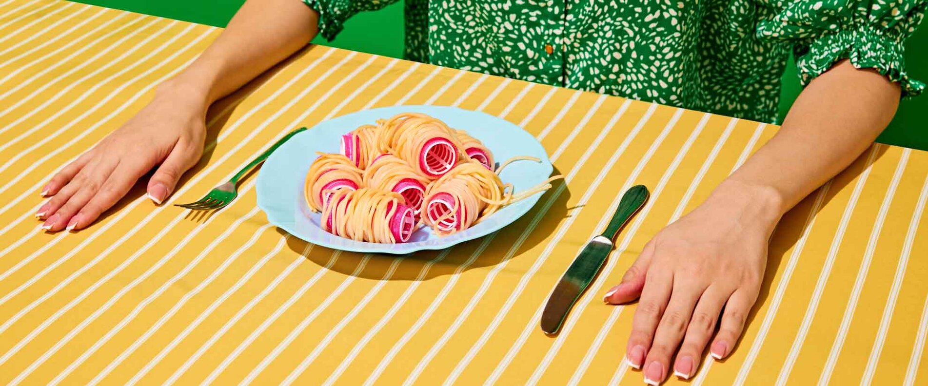 Dame am Esstisch mit Teller gefüllt mit Spaghetti auf Lockenwickler | © shutterstock