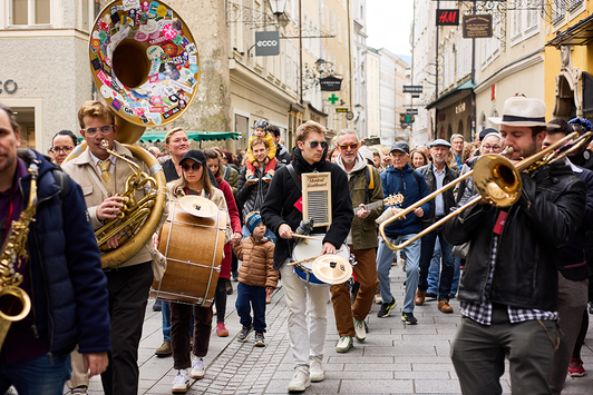 Die Mozarteum Marching Band marschiert musizierend durch die Salzburger Getreidegasse | © Henry Schulz