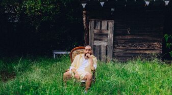 Ein Musiker sitzt in einem Garten | © Tanguy Delavet