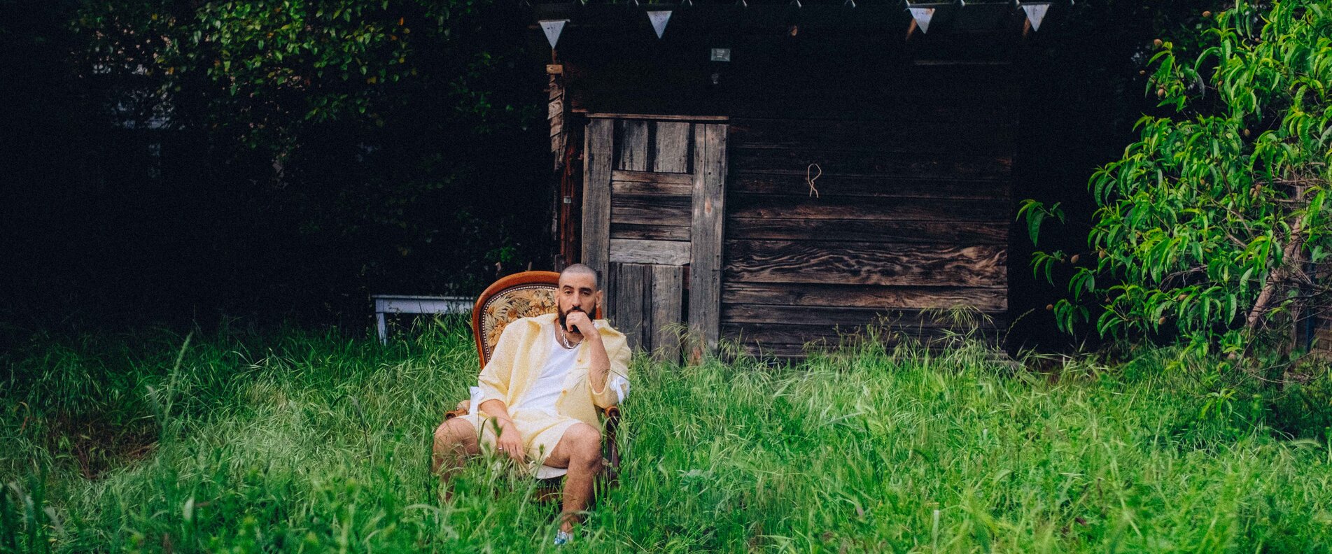 Ein Musiker sitzt in einem Garten | © Tanguy Delavet