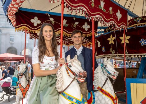 Salzburger Rupertikirtag fand vom 20. bis 24. September 2024 in der Salzburger Altstadt statt. Magdalena Gassner und Sebastian Aigner am nostalgischen Pferdekarussell  | © Andreas Kolarik