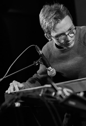 Foto in Schwarz-Weiß vom Musiker Fabian Schuhmann auf der Bühne.  | © Markus Lackinger