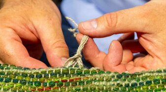 Handweberei Weiss - Hände die einen Teppich knüpfen | © Andreas Kolarik