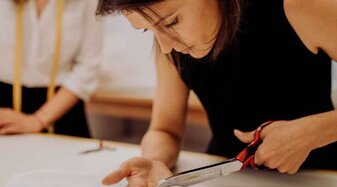 Schneiderin beim Stoff zuschneiden | © Das Kleid