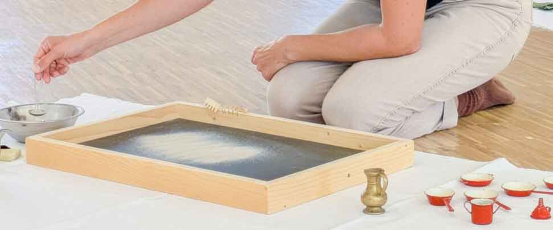 Eine Frau spielt mit Sand | © Salzburg Museum/Ortrun Heisler